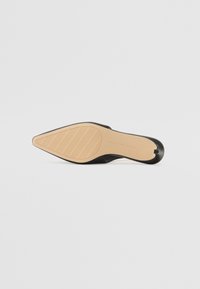 Black high-heeled shoe with a pointed toe, smooth upper material, and a beige textured sole featuring diagonal grooves.