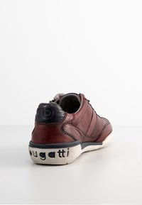 Sneaker da uomo color bordeaux con design in pelle e rete, dotato di colletto imbottito, accenti neri a contrasto e suola in gomma testurizzata.