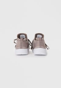 Schnürsneaker aus leichtbeigem Material mit strukturiertem Finish. Verfügt über eine graue Fersenschlaufe und eine weiße Gummisohle. Minimale Markenkennzeichnung sichtbar.