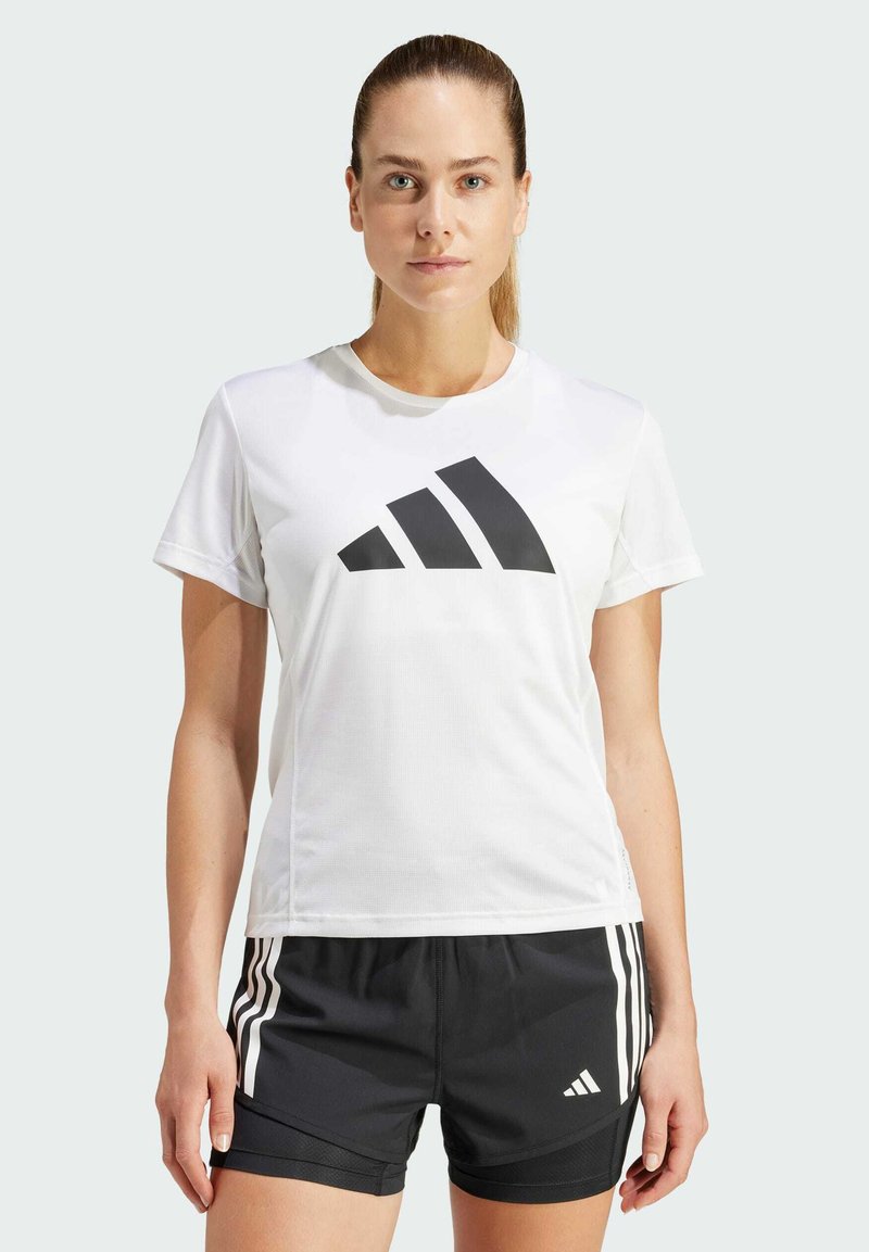 Weißes Sport-T-Shirt mit kurzen Ärmeln und einem großen schwarzen Adidas-Logo, kombiniert mit schwarzen Shorts, die weiße Streifen und Logo-Highlights aufweisen.