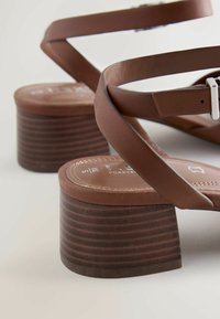 Sandalias marrones de cuero con tiras, tacones gruesos de madera y cierres de hebilla plateada, talla 38.