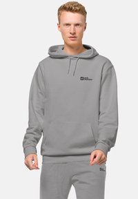 Felpa con cappuccio grigio chiaro, dotata di tasca frontale e logo nero sul petto. Presenta una vestibilità comoda, una texture morbida e polsini a costine.