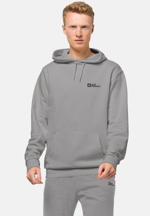 Felpa con cappuccio grigio chiaro, dotata di tasca frontale e logo nero sul petto. Presenta una vestibilità comoda, una texture morbida e polsini a costine.