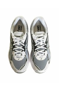 Coppia di scarpe da corsa ASICS bianche e nere con design in mesh e lacci, viste dall'alto su uno sfondo bianco.