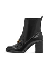 Botas de cuero negro hasta el tobillo con punta cuadrada, tacón grueso, detalle de cadena dorada en la parte frontal y una asa en la parte posterior. Textura suave.