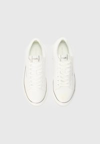Sneakers bianchi in pelle con design stringato, punta arrotondata, branding minimale e cuciture accentuate lungo il bordo della suola.