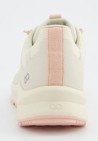 Baskets de couleur claire avec une tige en tissu texturé, un accent rose au talon et une semelle rembourrée avec un motif en relief.