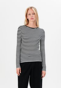 Black and white striped long-sleeve top with a round neckline, made from a soft fabric, featuring a fitted design and contrasting cuffs.
