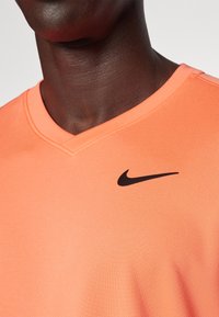 Nike Performance TOP - T-skjorte til trening - light wild mango/black