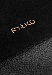 Czarna torebka z zamszu i skórki teksturowej z wytłoczonym na złoto logo "RYŁKO". Gładkie i miękkie wykończenie, bez widocznych elementów metalowych czy wzorów.