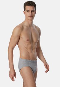 Boxer briefs grigi in cotone con un design aderente e una vita senza cuciture, mostrati su un modello maschile su uno sfondo semplice.