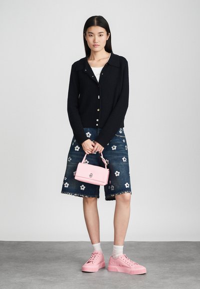 Melnas ribotas kardigāns ar pogu aizdari, ziedu izšūta džinsu svārki, rozā rokassoma un rozā platformas čības.