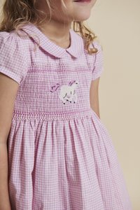 Rozā un baltas krāsas rūtainas kleita ar īsām uzpūstām piedurknēm, smocked krūtīm un izšūtu vienradža dizainu. Viegls, mīksts audums.