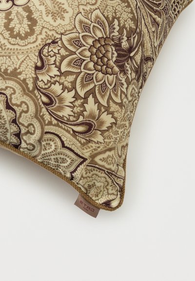 Coussin décoratif aux motifs floraux et cachemire beige, marron et crème complexes, avec une petite étiquette en tissu portant l'inscription « ETRO HOME ».