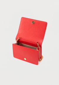 Κόκκινο δερμάτινο πορτοφόλι με υφή, χρυσά μεταλλικά στοιχεία και λουρί με αλυσίδα. Διαθέτει κούμπωμα με κουμπί και ευρύχωρο, ανοιχτό εσωτερικό.