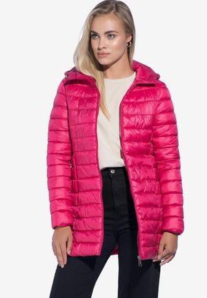 Fuchsia pufferjack met horizontale stiksels, vaste capuchon, ritssluiting aan de voorkant en zakken, gedragen over een lichtgewicht top en zwarte broek.