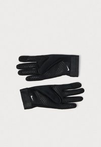 Fekete Nike sportkesztyű pár, szellőzőlyukakkal és fehér swoosh logókkal a hátoldalon, sík felületen elhelyezve.
