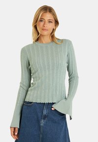 Hellgrüner Langarmpullover mit vertikal gerippter Textur, dezenten Rautenmuster und ausgestellten Bündchen. Weiches, elastisches Material.