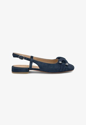 Ballerine in suede blu navy con tacco basso a blocco, caratterizzate da un dettaglio annodato sulla punta e un elemento metallico circolare.