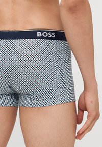 Boxers pour hommes en tissu léger avec un motif à pois bleu et blanc. Dotés d'une ceinture noire avec le logo "BOSS".