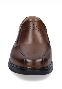 Brown leather slip-on shoe with perforated details, rounded toe, and contrasting black rubber sole. Smooth texture with subtle sheen.