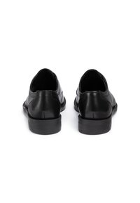 Scarpe in pelle nera con una texture liscia, forma arrotondata e tacco in gomma basso. Presentano un design minimalista senza accenti o motivi visibili.