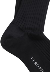 Calze nere a coste con una texture liscia, dotate di punta rinforzata e etichetta bianca con la scritta "PEROFIL". Design semplice e funzionale.
