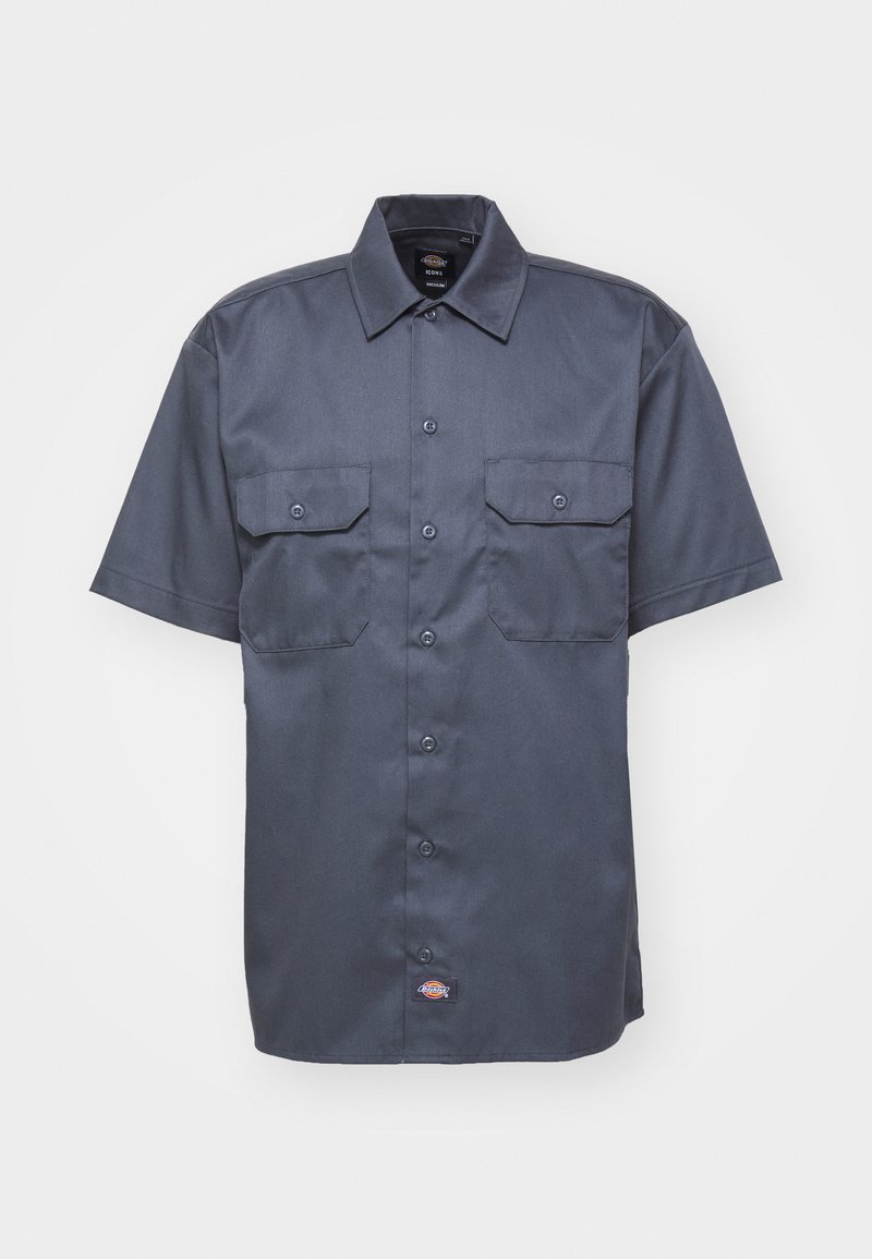 Camicia a maniche corte di colore blu navy scuro, realizzata in tessuto morbido, con chiusura a bottoni frontale, due tasche sul petto e un piccolo logo sull'orlo inferiore.
