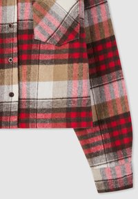 Camicia in flanella a quadri con blocchi di colore rosso, nero, marrone e bianco, dal design corto e chiusure a bottone sulle tasche frontali.