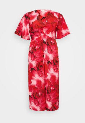 Vestido floral rojo con escote en V, mangas cortas y acogedoras, y un detalle de lazo en la cintura. Tela suave con un patrón colorido y llamativo.