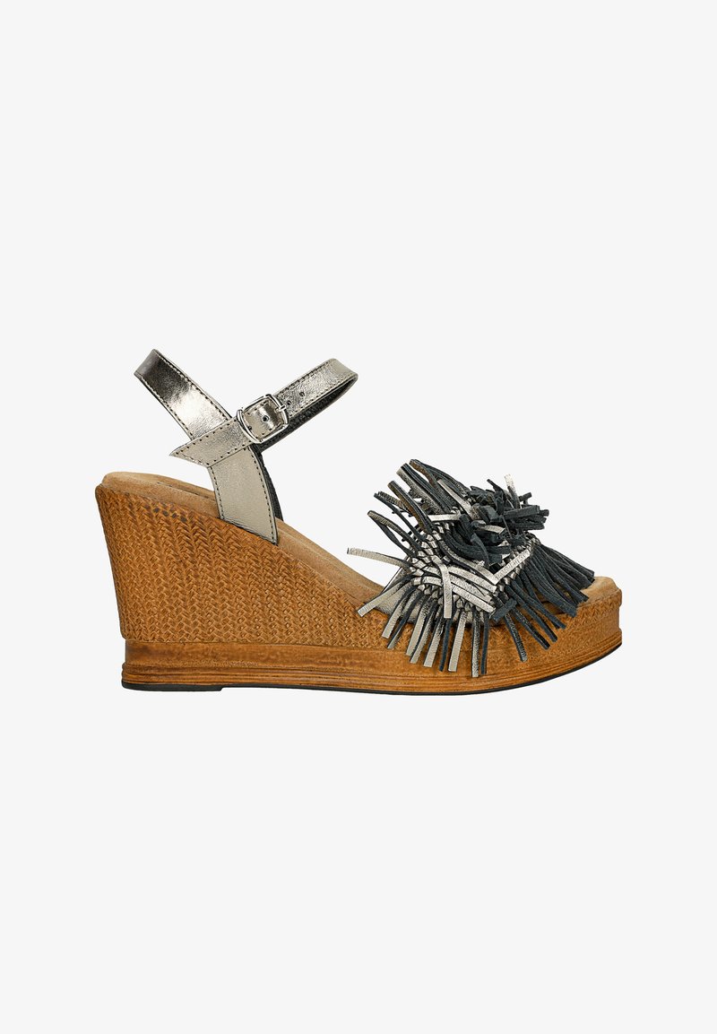 Sandál na klínku s tkaným hnědým základem, kovově stříbrným páskem kolem kotníku a dekoračními třásněmi v odstínech černé a stříbrné.