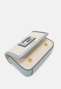 Béžová textilní kabelka se světle modrými strukturovanými detaily, obsahující přední klopu, zlaté zapínání na patent a detail s logem.