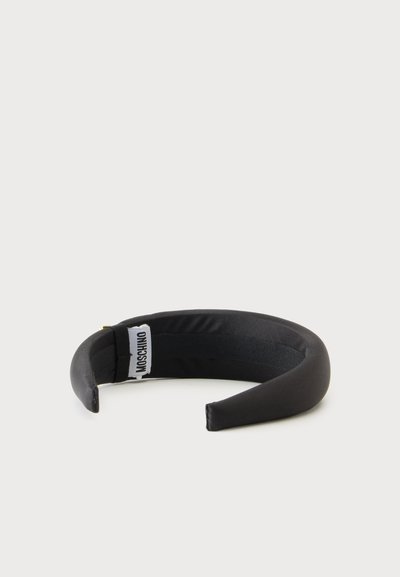 Bandeau noir rembourré avec une étiquette logo Moschino en tissu sur le côté intérieur, présenté sur un fond clair uni.