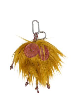 Puszysty, żółty breloczek z dwoma okrągłymi, przezroczystymi różowymi dyskami; zawiera srebrny karabińczyk i teksturowane włókna.