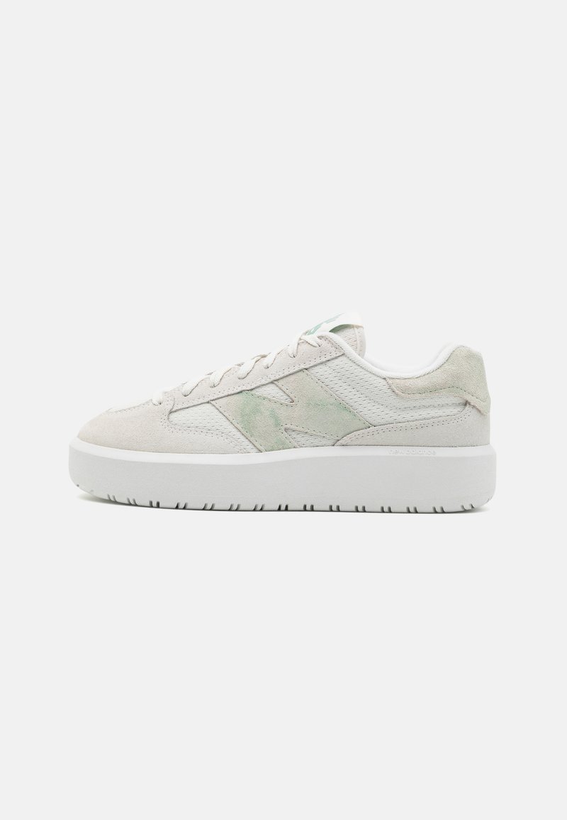 Helle Sneaker mit einem strukturierten Obermaterial aus Wildleder und Mesh, das einen subtilen grünen Akzent aufweist, flachen Schnürsenkeln und einer dicken weißen Gummisohle.