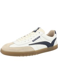 Zapatillas blancas y beige con una punta de ante, acentos en azul marino, una lengüeta de malla texturizada y suela de goma con patrón de zigzag.