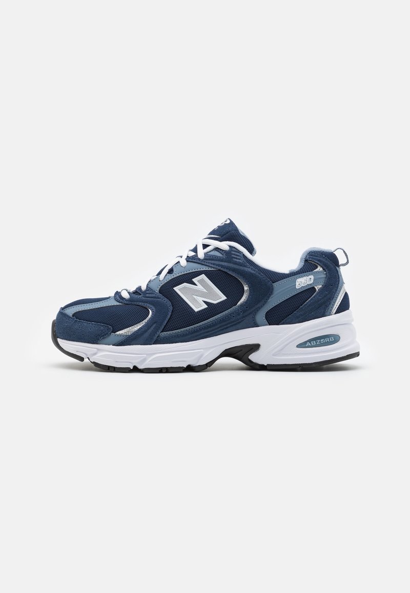 Navy athletic sneaker featuring a textured mesh and suede upper, white accents, an ABZORB midsole, and a rounded toe design.
