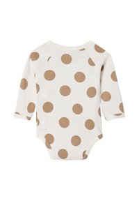 Langärmliger Body in Creme mit großen braunen Punkten. Baumwollmaterial mit Rundhalsausschnitt und Druckknopfverschluss am Boden.