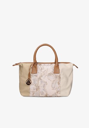 Sac fourre-tout beige et crème avec poignées en cuir marron clair, panneau central brodé de fleurs, et un pendentif rond doré de la marque suspendu à la poignée.