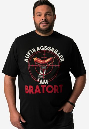 T-shirt noir en coton avec un graphique central représentant une fourchette et une saucisse entourées de cercles rouges, le texte indique « AUFTRAGSGRILLER AM BRATOR T. »