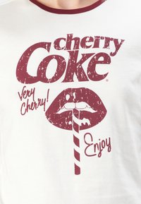 White T-shirt featuring a maroon graphic design with "cherry Coke" text and a stylized mouth with a straw, and "Enjoy!" text below.