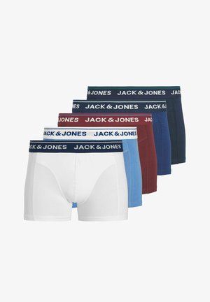 Noor mees lühikeste blondide juustega, kandes valgeid Jack & Jones bokseraluspükse, seisab ühevärvilise heleda tausta ees ja vaatab otse ettepoole.