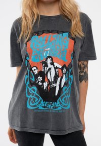 Gray oversized t-shirt featuring a colorful graphic print of band members with "Rolling Stones" text, textured fabric, and short sleeves.