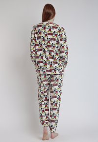 Conjunto de pijama de forro polar con temática de Mickey Mouse que presenta un estampado repetido de personajes coloridos en negro, rojo, amarillo y blanco. Textura suave.