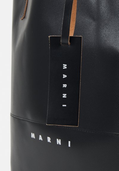 Borsa tote nera con finitura testurizzata, caratterizzata da un'etichetta in pelle con la scritta "MARNI" stampata in bianco e dettagli in pelle marrone chiaro a contrasto.
