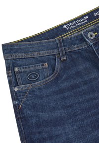 Dunkelblaue Jeans mit gelben Nähten, ausgestattet mit einer Gesäßtasche, einem Logo am Bund und einem standardmäßigen Knopf- und Reißverschluss.