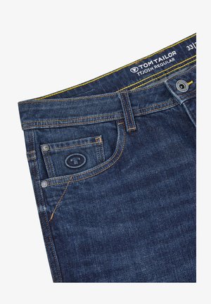 Donkerblauwe denim jeans met gele stiksels, uitgerust met een voorzak, logo op de tailleband en een standaard knoop- en ritssluiting.