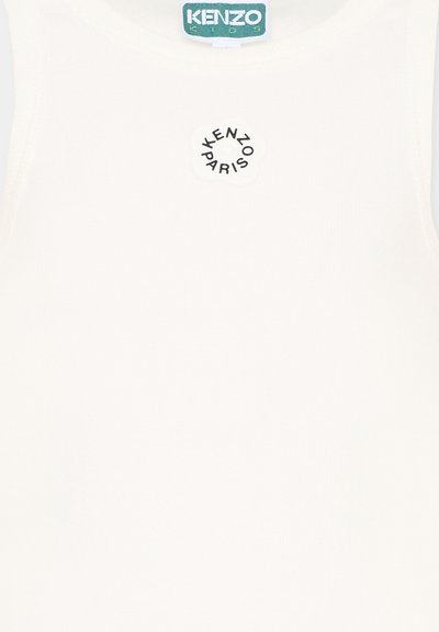 Biały materiał z okrągłym czarnym logo „KENZO PARIS” oraz zieloną metką „KENZO KIDS” na środku u góry.