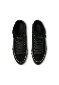 Czarne zamszowe sneakersy o teksturowanej powierzchni, z elementami w odcieniu złota, grubymi sznurówkami i kontrastującą gumową podeszwą.