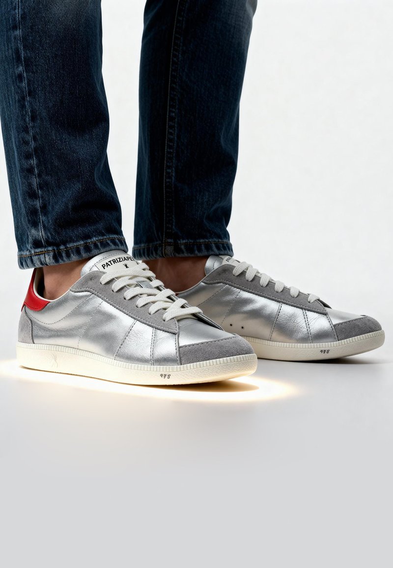 Zilveren sneakers met grijze suede accenten, rode hieldetails en witte veters. Opvallende verlichte zool en gestructureerd oppervlak. Klassiek ontwerp.